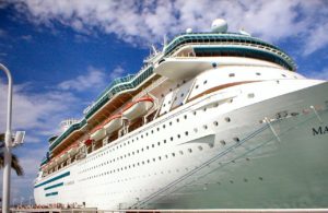 A Royal Caribbean Cruise Ship in port at Key West, Florida with many windows and decks along with a blue sky with light clouds