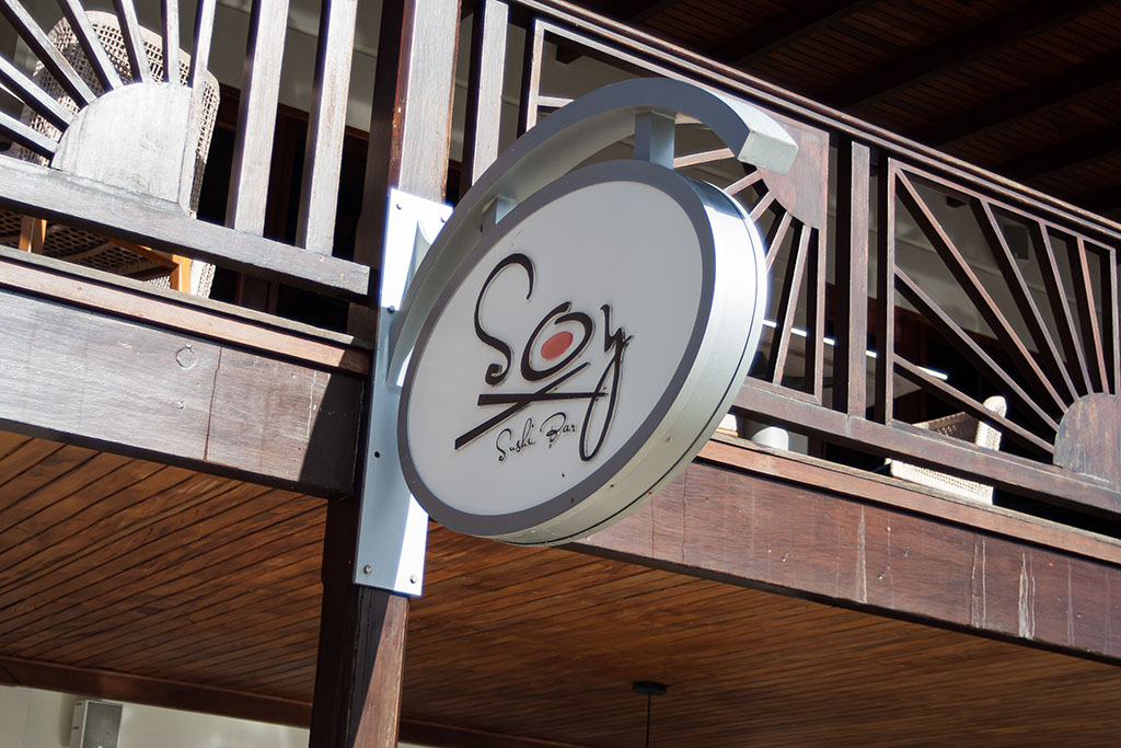 A picture of the Soy sign above the restaurant and open seating area at another restaurant above Soy