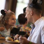 a father and daughter eating breakfast at a restaurant at one of the Disney Parks